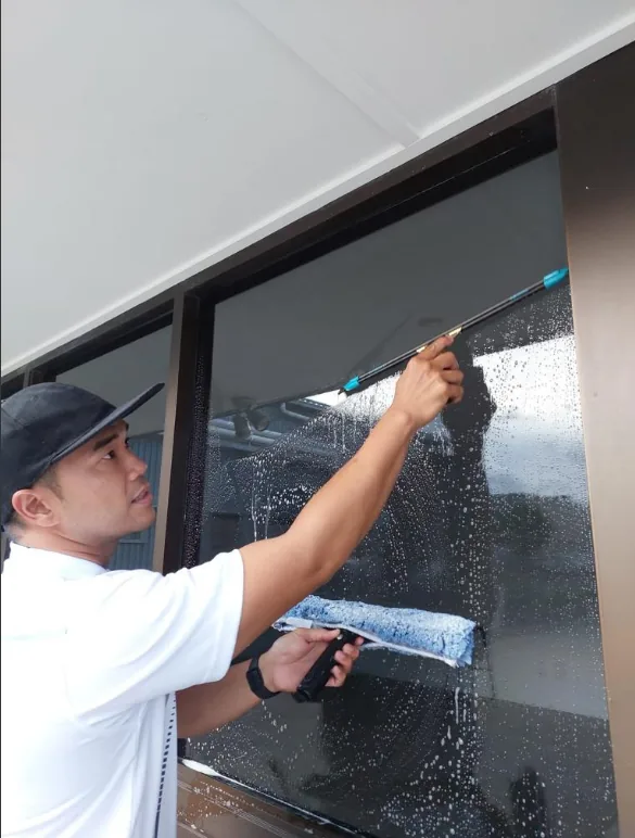 Jordan working a squeegee across a window pane
